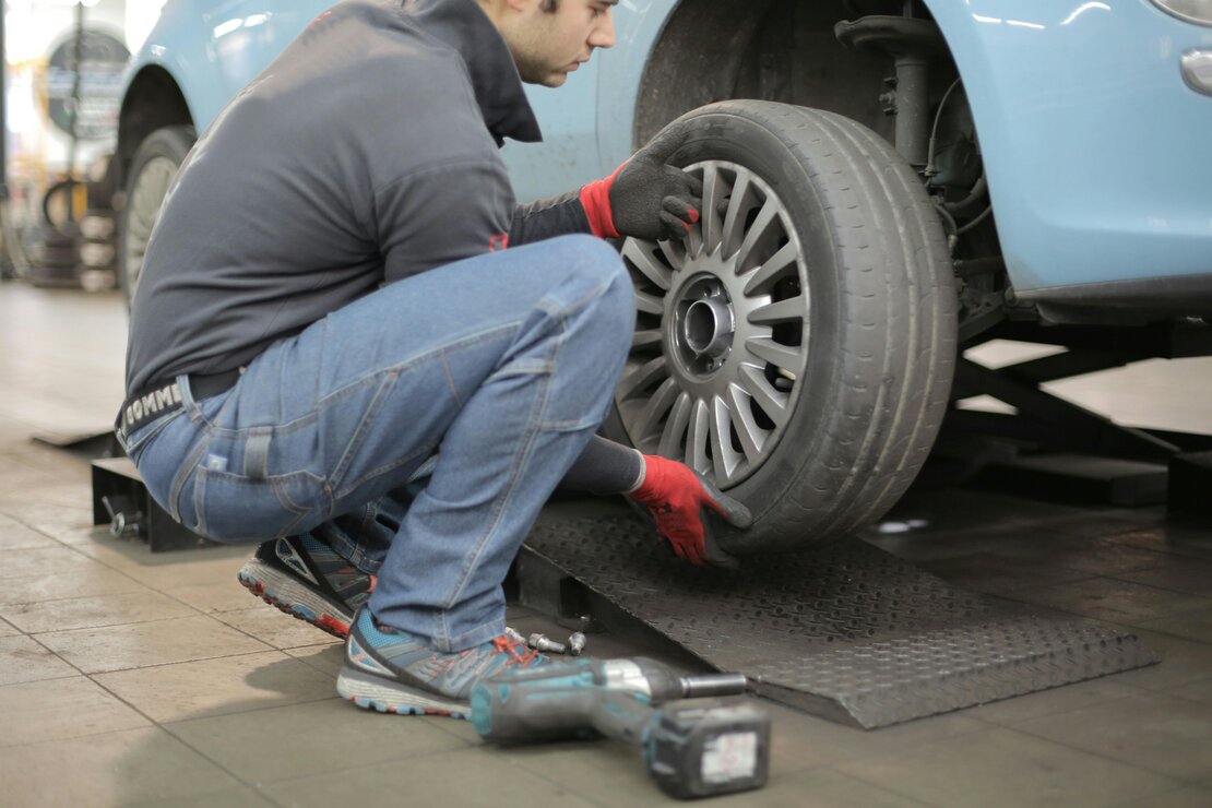 Mechanik naprawiający auto na poboczu